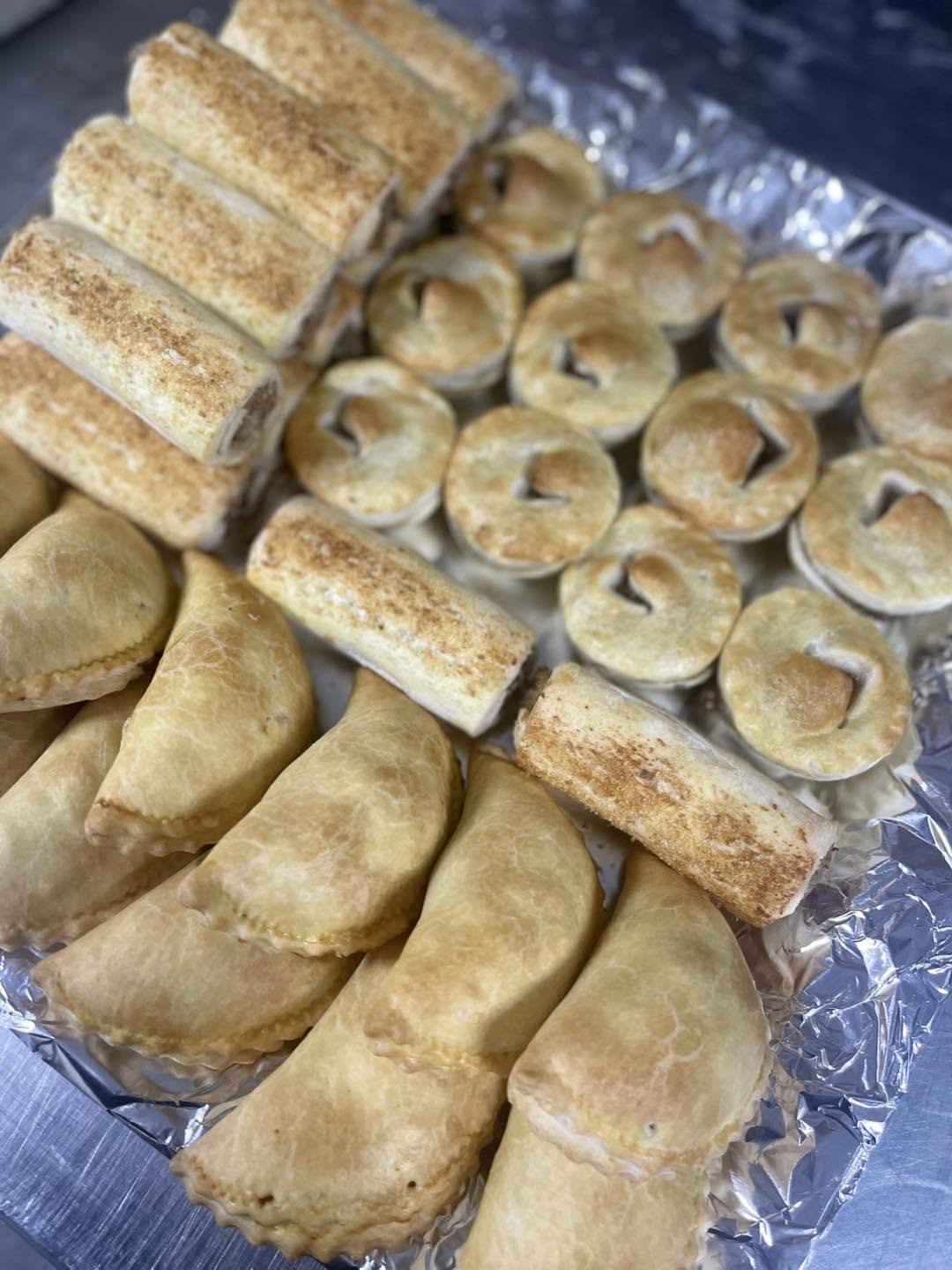 Close view of sausage rolls, pasties and mini pies fresh from the oven